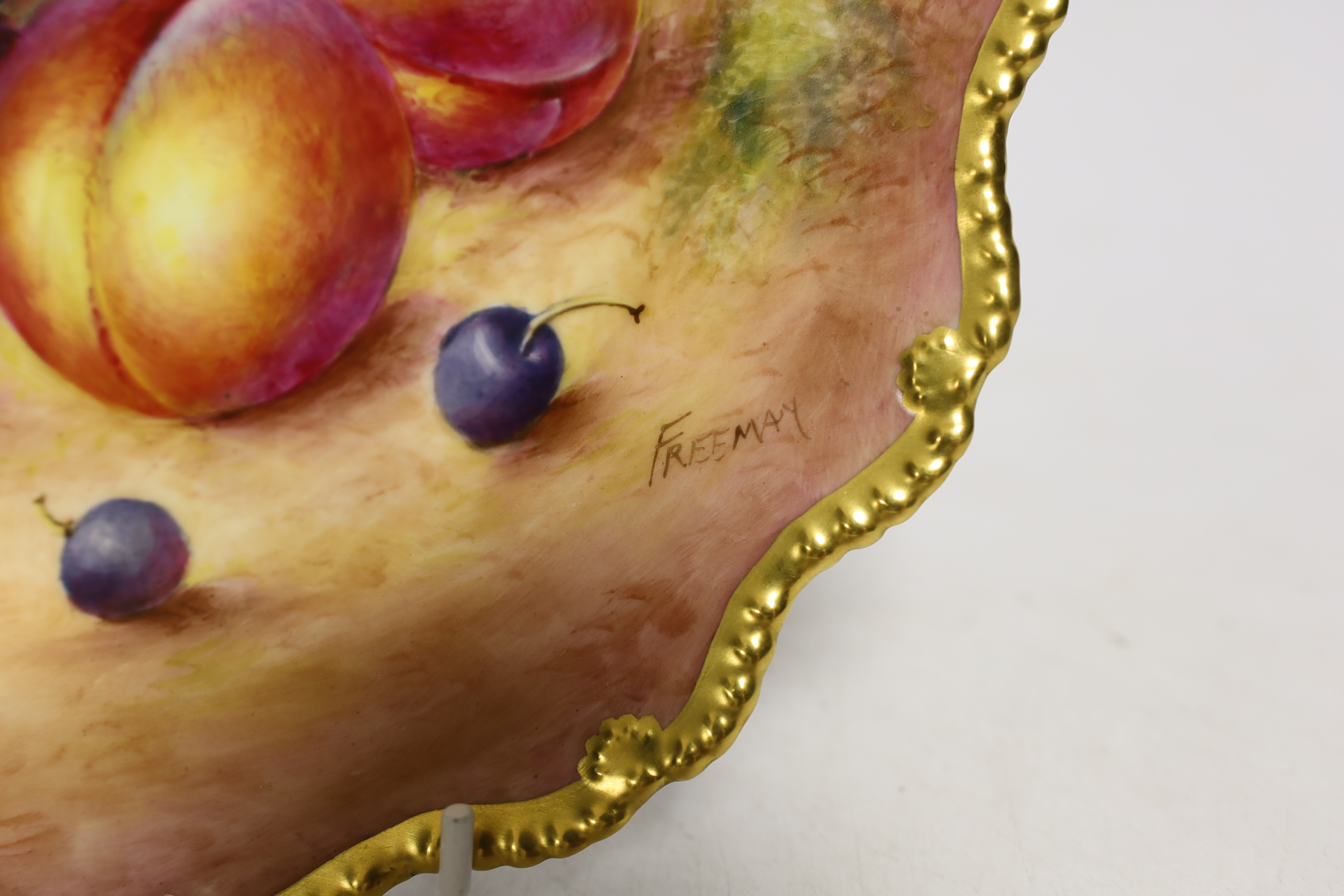 A pair of Royal Worcester fruit painted plates, post war, signed Freeman, 22.5cm